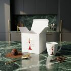 Espresso cup “Shine Like a Star”, limited edition designer espresso cup with artistic illustration by NONOS, stylish porcelain cup with saucer, coffee being poured, close-up view.