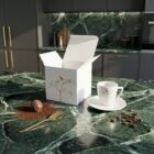 Espressotasse „Kolibri“, limitierte Designer-Espressotasse aus Porzellan mit feiner Kolibri-Illustration und goldenen Akzenten von NONOS, Espressotasse mit Untertasse auf Marmortisch, stilvolle Kaffee-Inszenierung.